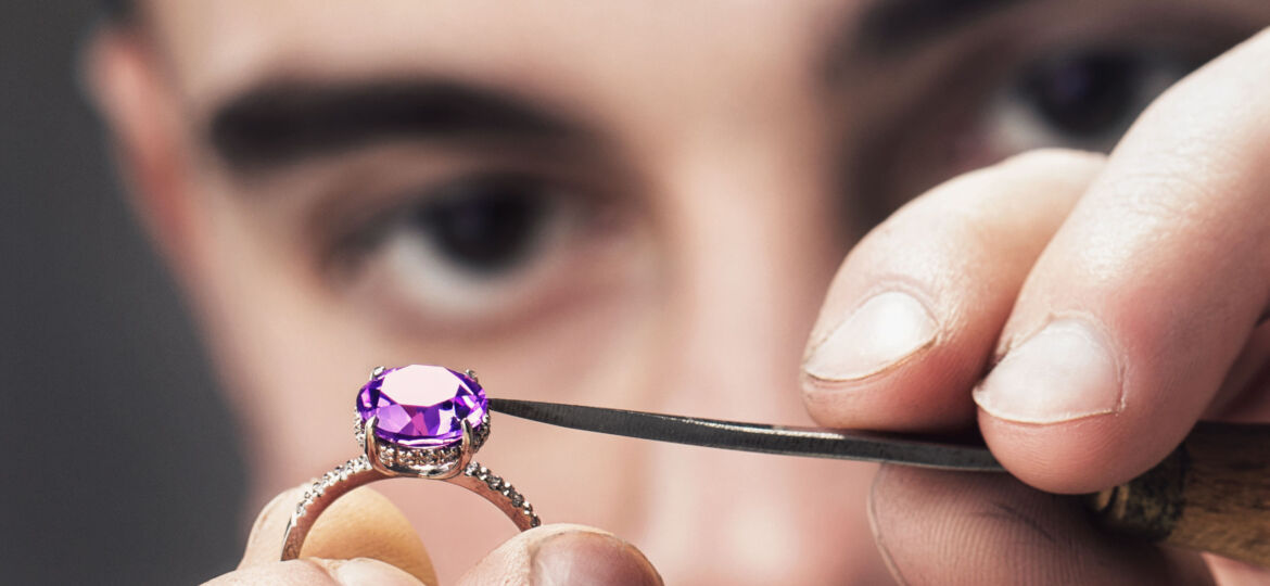 Image of Master Jeweler examines the gold ring for defects close-up