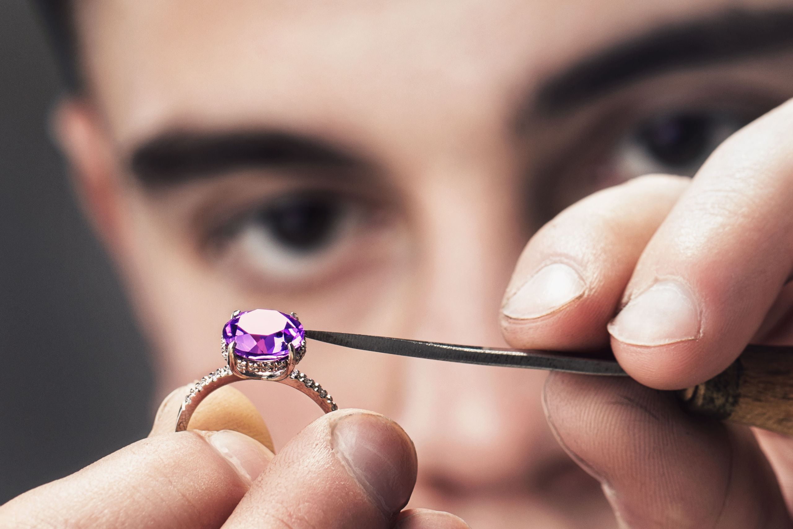 Image of Master Jeweler examines the gold ring for defects close-up
